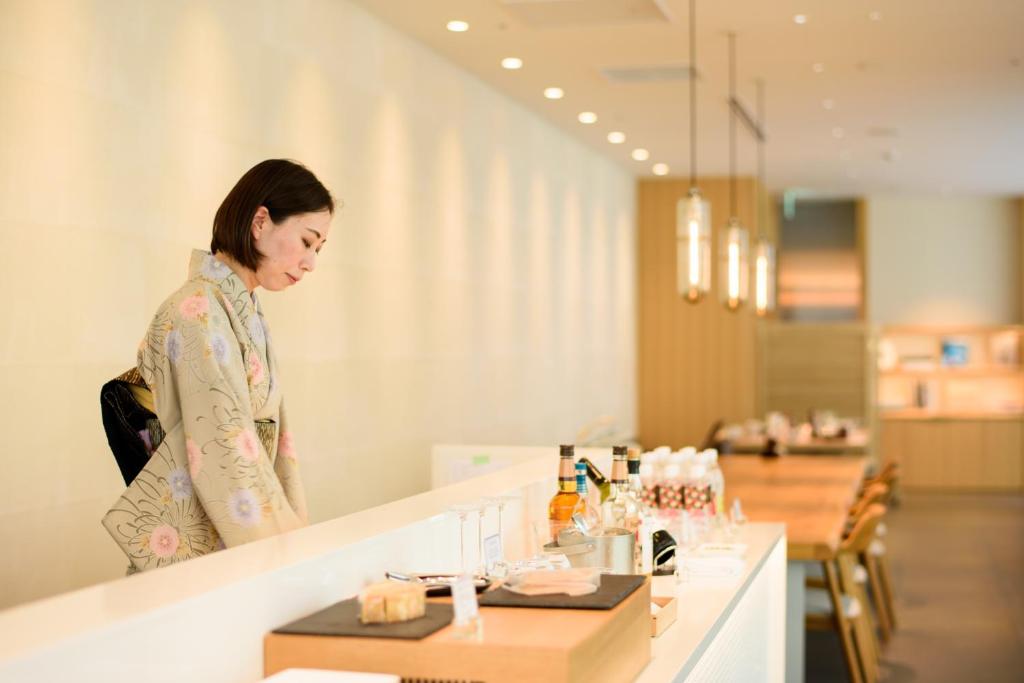 a woman standing at a counter in a room at Kanazawa Tokyu Hotel in Kanazawa