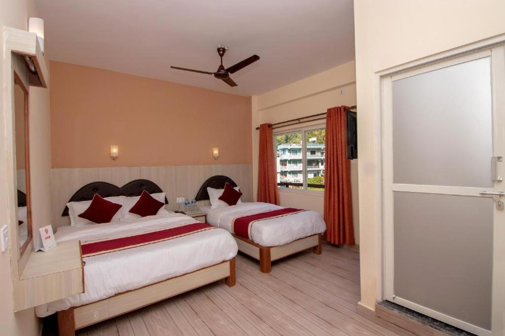 Habitación de hotel con 2 camas y ventana en The Country Yard, en Pokhara