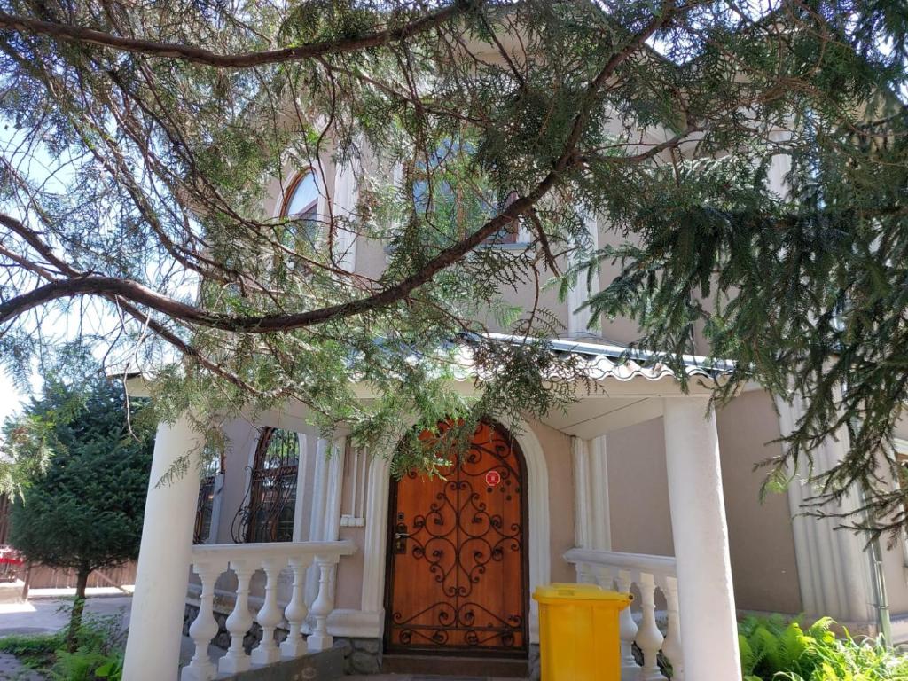 una casa con una puerta roja y una valla blanca en Assem Hostel Dostyk, en Almaty