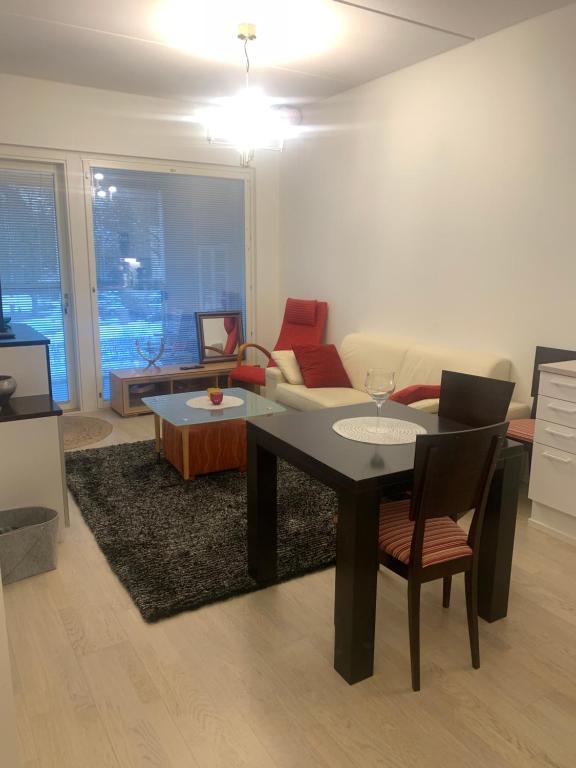 a living room with a table and a couch at Modern Apartment nearby Airport in Vantaa