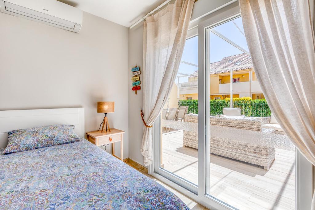 sypialnia z łóżkiem i przesuwanymi szklanymi drzwiami w obiekcie Hanami Puerto Alto PA 4-4 w mieście Estepona