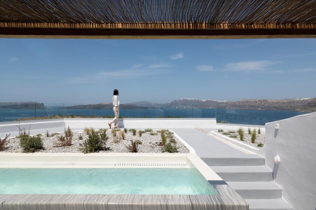vista su una piscina con un faro sullo sfondo di Hotel Goulielmos ad Akrotírion