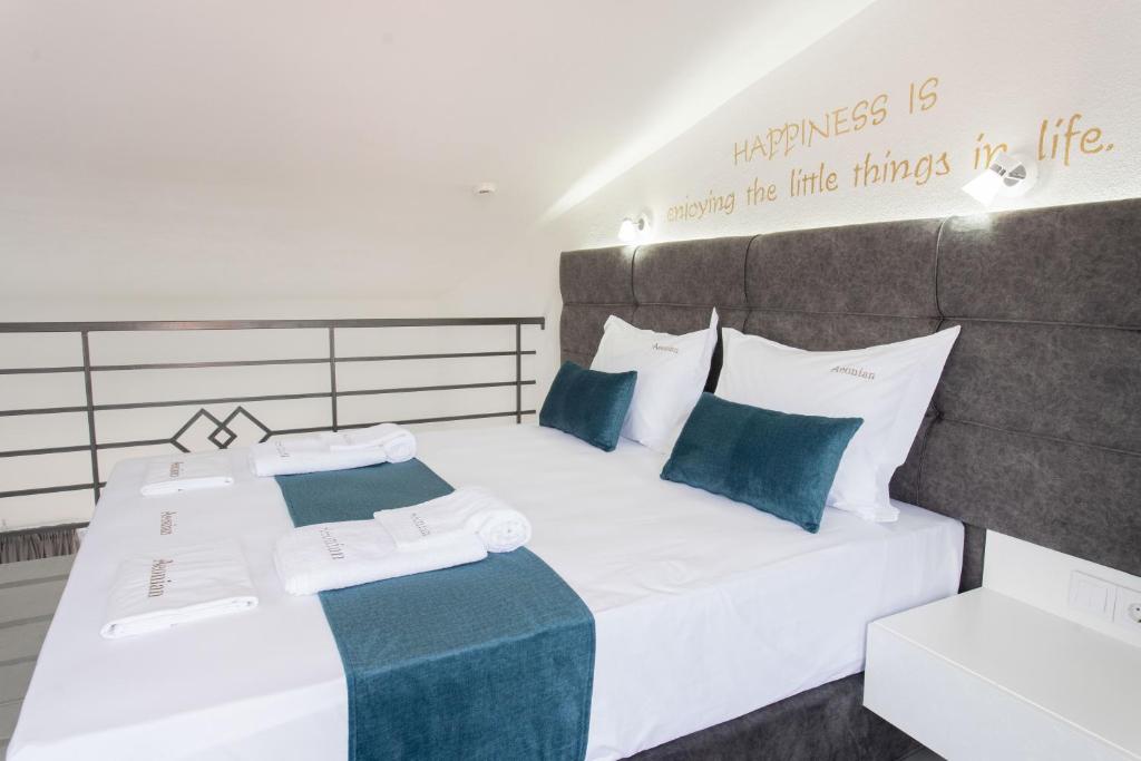 a bedroom with two beds with blue and white pillows at Aeonian Luxury Suites Asprovalta, Adults Only & Kids 12 Plus in Asprovalta