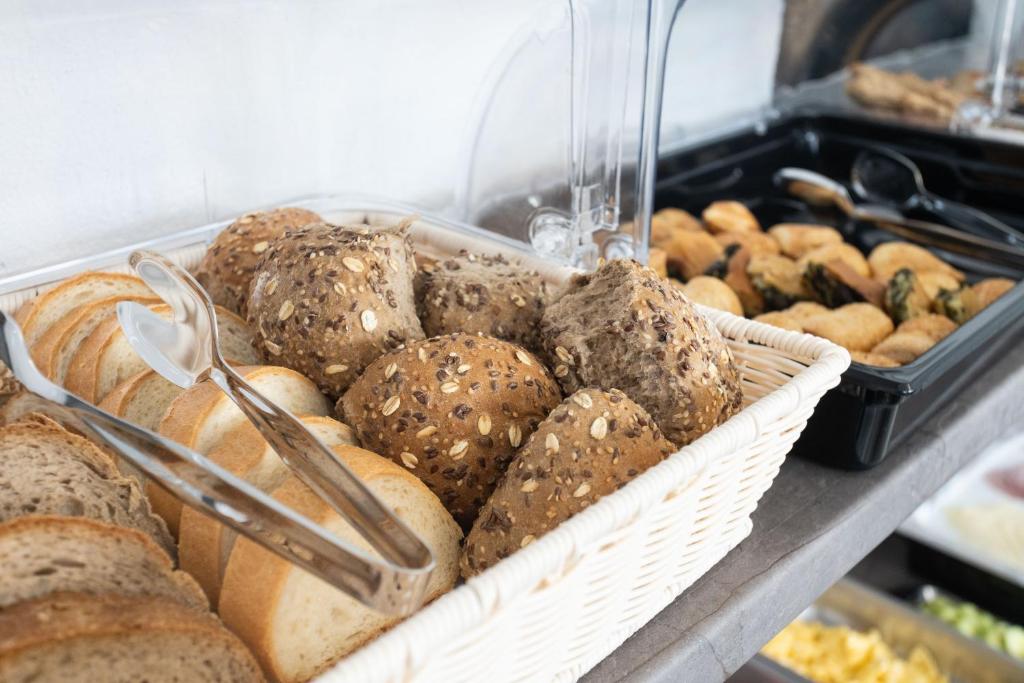 a bunch of different types of bread in a basket at Aeonian Luxury Suites Asprovalta, Adults Only & Kids 12 Plus in Asprovalta