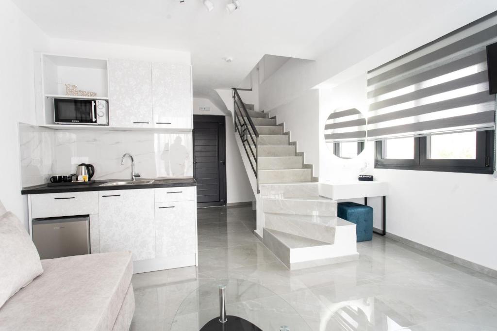 a kitchen with white cabinets and a staircase at Aeonian Luxury Suites Asprovalta, Adults Only & Kids 12 Plus in Asprovalta