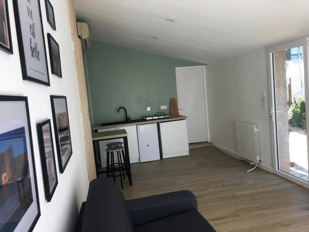 ein Wohnzimmer mit einem Sofa und einer Küche in der Unterkunft Studio refait à neuf avec jardin Aigues Mortes in Aigues-Mortes