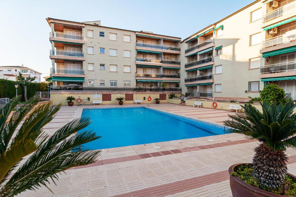 コマルガにあるNear beaches large private patio, aircon & community poolの一部のアパートメントビルの前にスイミングプールがあります。