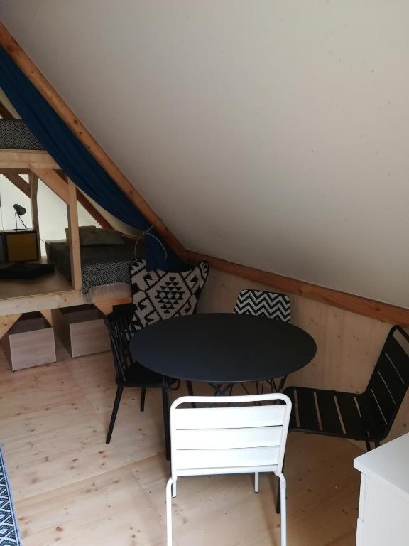 a room with a table and chairs in a attic at Camping Du Port De Plaisance in Péronne