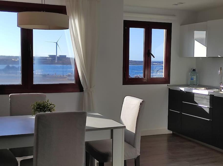 cocina con mesa y sillas y vistas al océano en ATALAYA SUNSET terrazza panoramica privata con vista al mare, en Corralejo