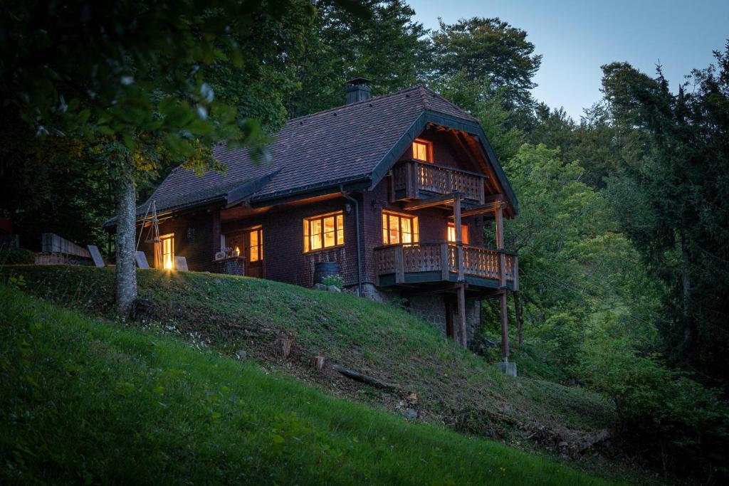 una casa de madera en una colina con sus luces encendidas en Chalet Abnona, en Wieden