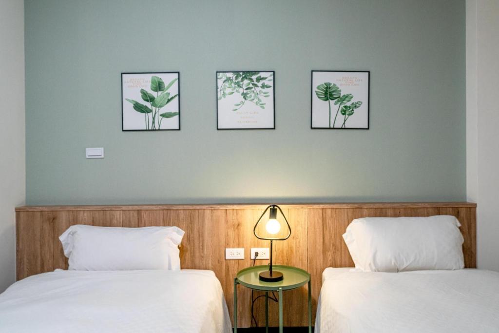 台南的住宿－公園綠驛，墙上有三张照片的房间的两张床