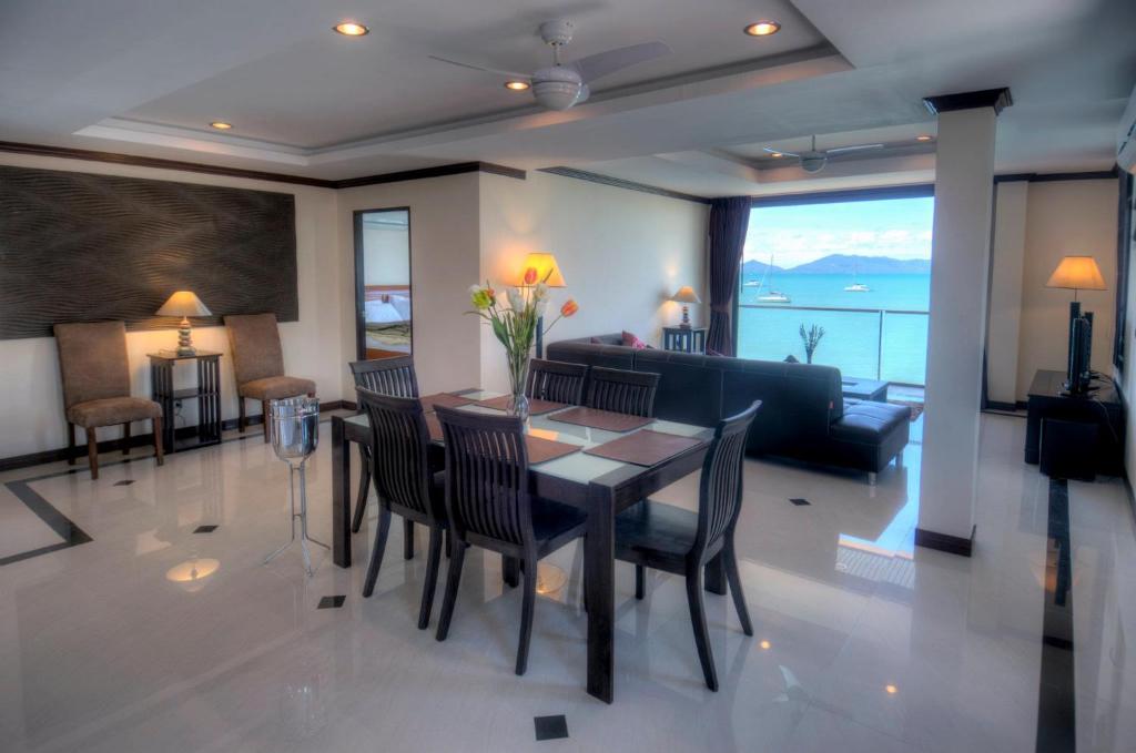 una sala da pranzo e un soggiorno con tavolo e sedie. di Emerald Beach-Front Apartments Fishermans Village a Ko Samui