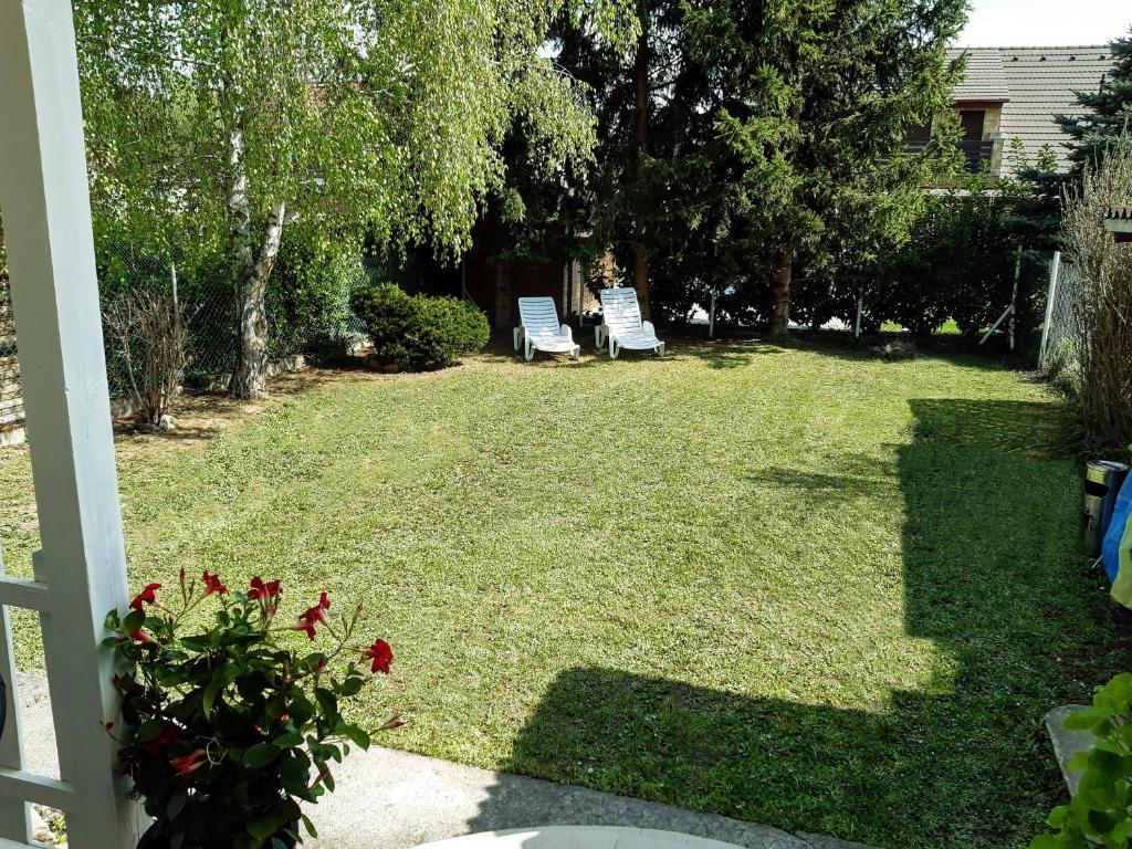 podwórze z dwoma krzesłami w trawie w obiekcie Holiday Home Balatonszárszó w mieście Balatonszárszó