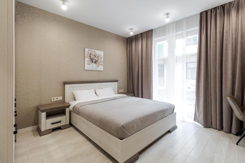 um quarto com uma cama e uma grande janela em Magic Apart 31 em Lviv