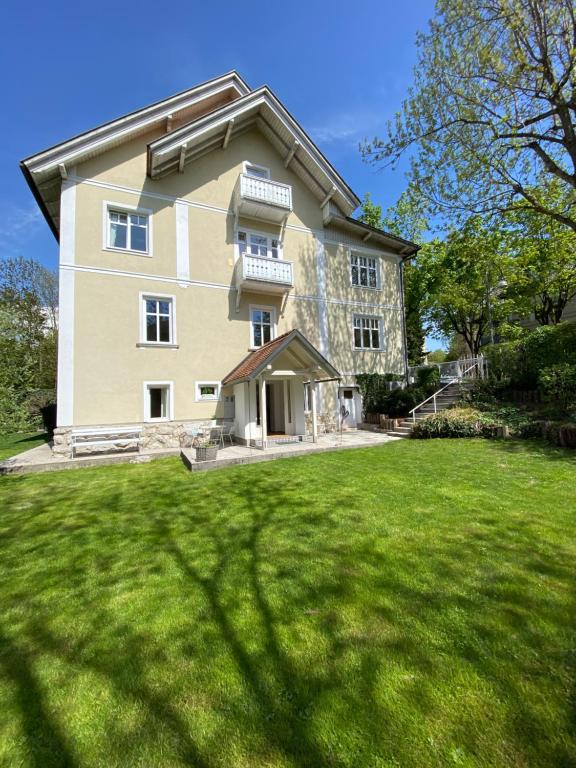 een groot huis met een groen gazon ervoor bij Historical Villa in the heart of Bled 2 in Bled