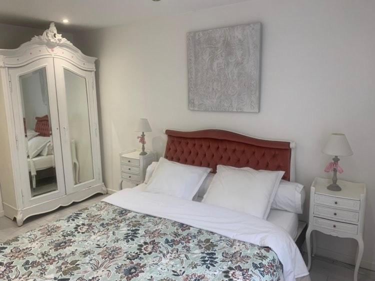 Un dormitorio con una cama grande y un espejo. en Maison avec terrasse Colmar Centre-Cottage garden terrace Center Old Town Colmar, en Colmar