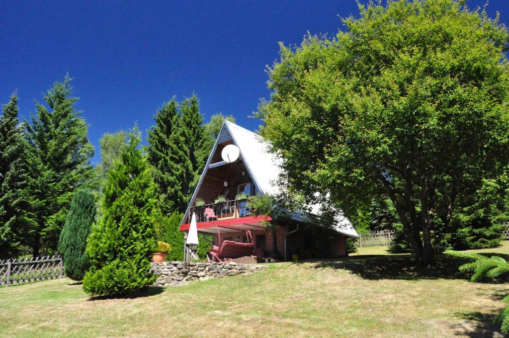 a small house with a pointed roof in a field at Finnhütte im Herzen des Thüringer Wald/ Haus Alwin in Heidersbach