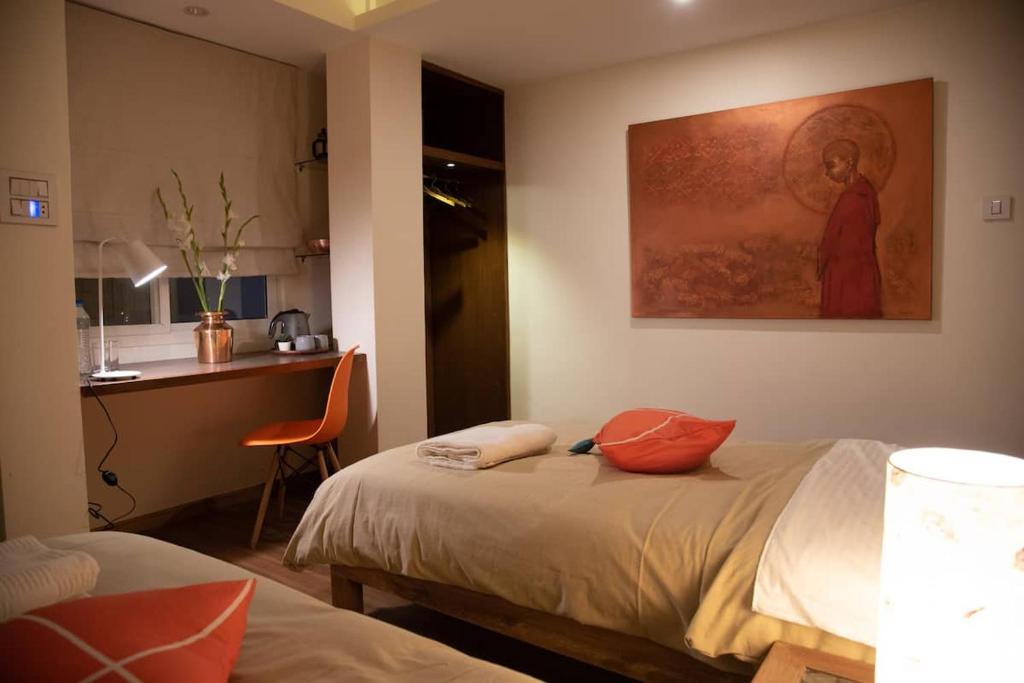una camera da letto con un letto con cuscini arancioni sopra di TARA ART HOUSE a Patan