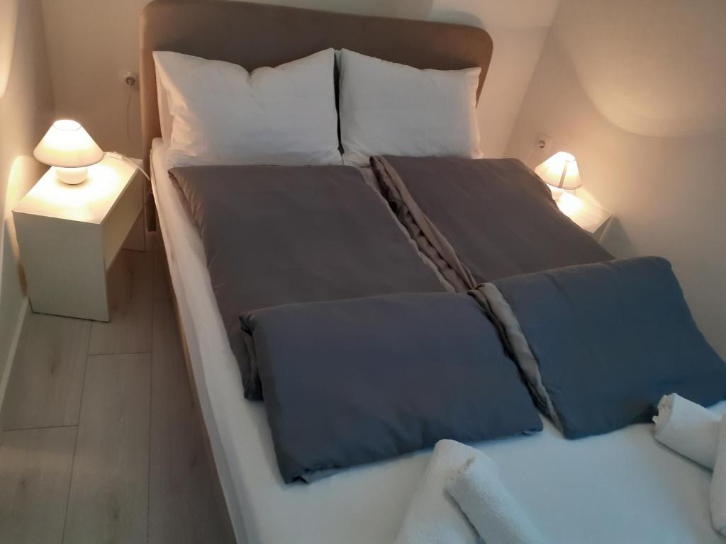 sypialnia z dużym łóżkiem z niebieską pościelą i poduszkami w obiekcie Studio apartman LORENA w mieście Zadar