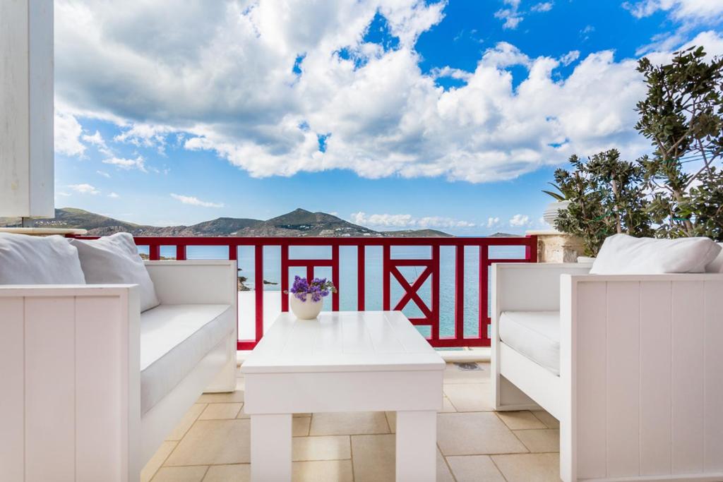 a balcony with white furniture and a view of the mountains at Katerina mare in Naousa