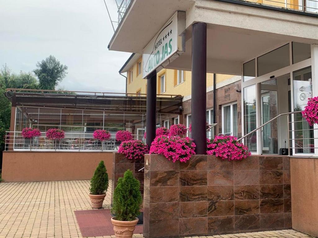 a store front with pink flowers in potted plants at Hotel Auto Jas in Nitra