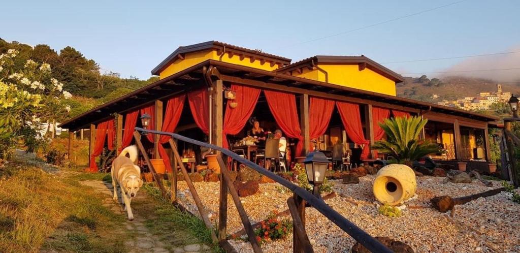 una pequeña casa con un edificio rojo y amarillo en B&B Aloe Ranch Elba en Rio nellʼElba