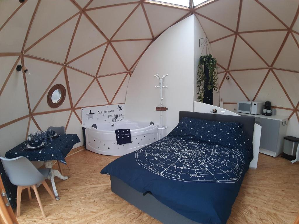 ein Schlafzimmer mit einem Bett und einer Badewanne in einer Jurte in der Unterkunft Dôme La vue étoilée in Poinson-lès-Fays
