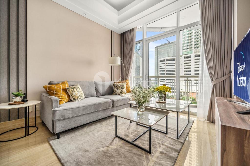 een woonkamer met een bank en een tafel bij M-aple by Kozystay - Setiabudi in Jakarta
