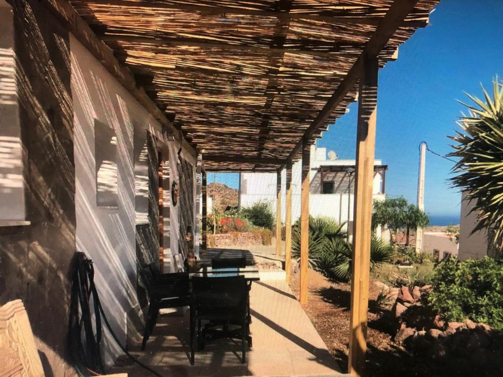 una pérgola de madera en el lateral de una casa en apartamento en Almería
