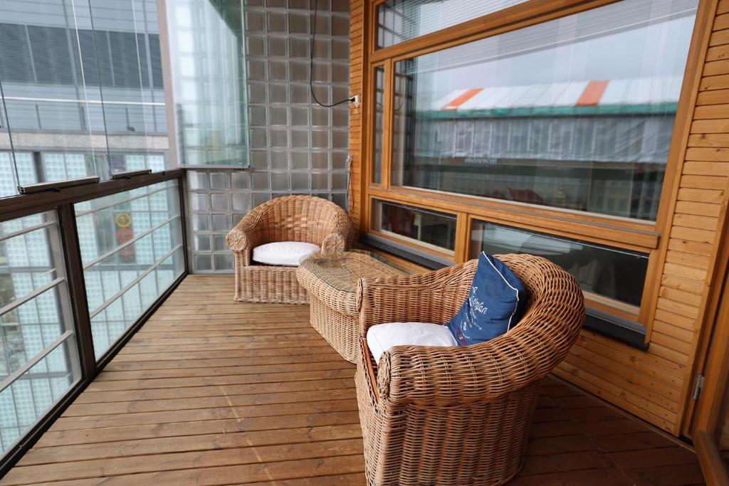 a balcony with two wicker chairs and a window at 2ndhomes Premium 1BR apartment with Sauna and Balcony in Kamppi Center in Helsinki