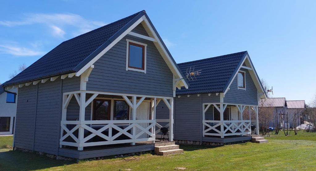 une maison bleue avec un toit en gambrel dans l'établissement Domki Reston, à Jastrzębia Góra