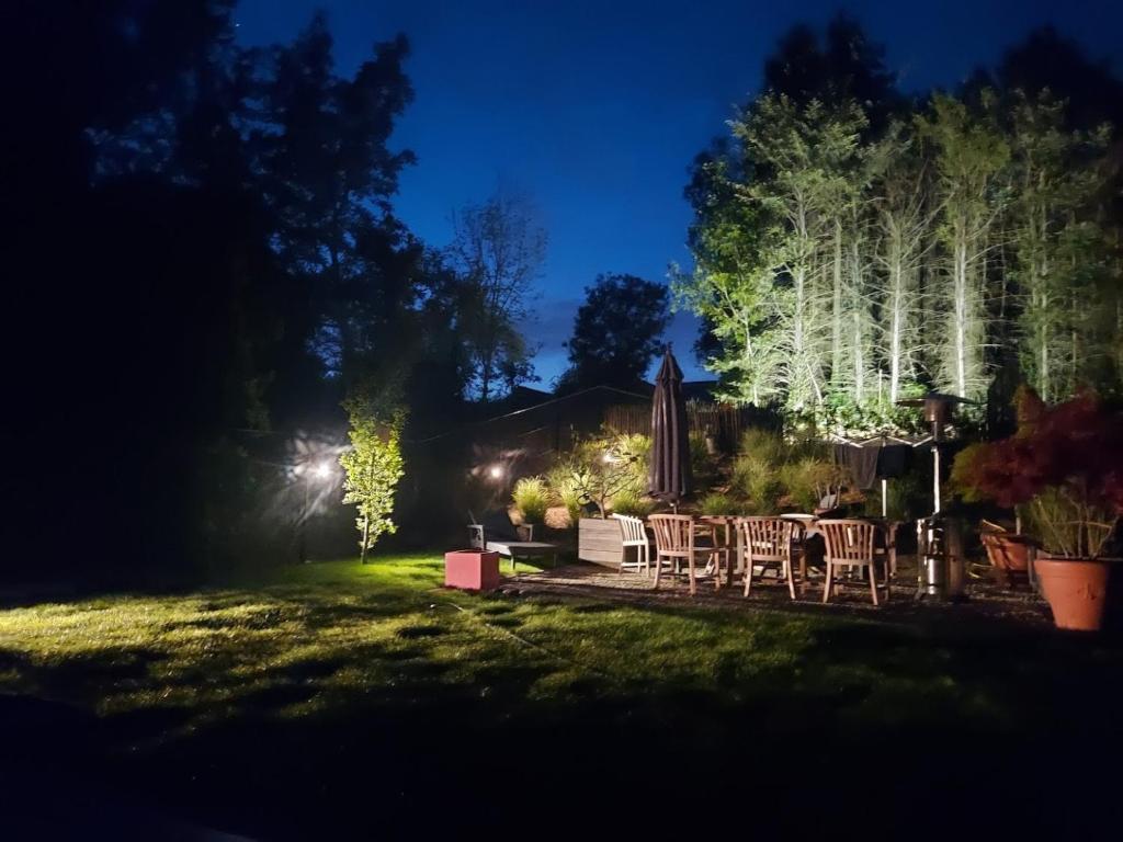 a backyard at night with chairs and tables at Vakantiewoning Bisonder in Bilzen