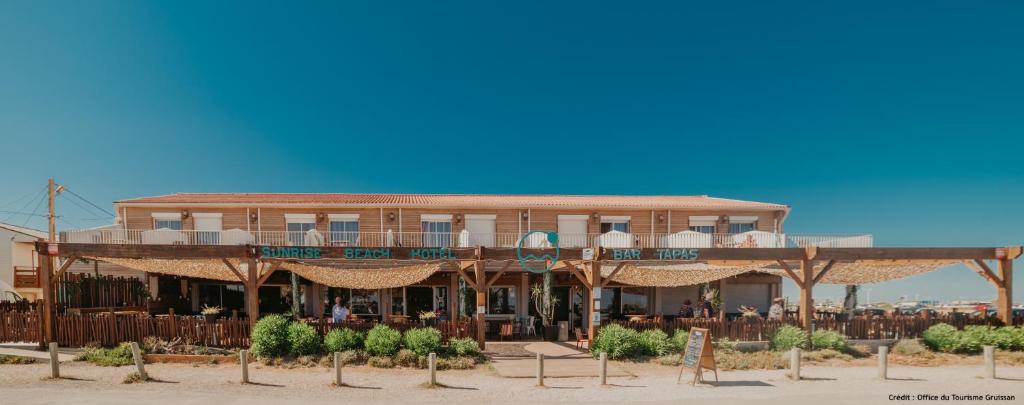 ein Gebäude mit einem Restaurant am Strand in der Unterkunft Sunrise Beach Hotel in Gruissan