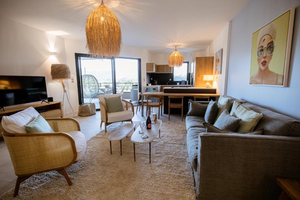 un salon avec un canapé, des chaises et une table dans l'établissement Appartement de luxe pour des vacances paisibles., à Porto-Vecchio