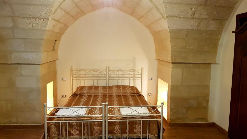 una camera con letto ad arco di Uliveto Sant' Isidoro a Maglie