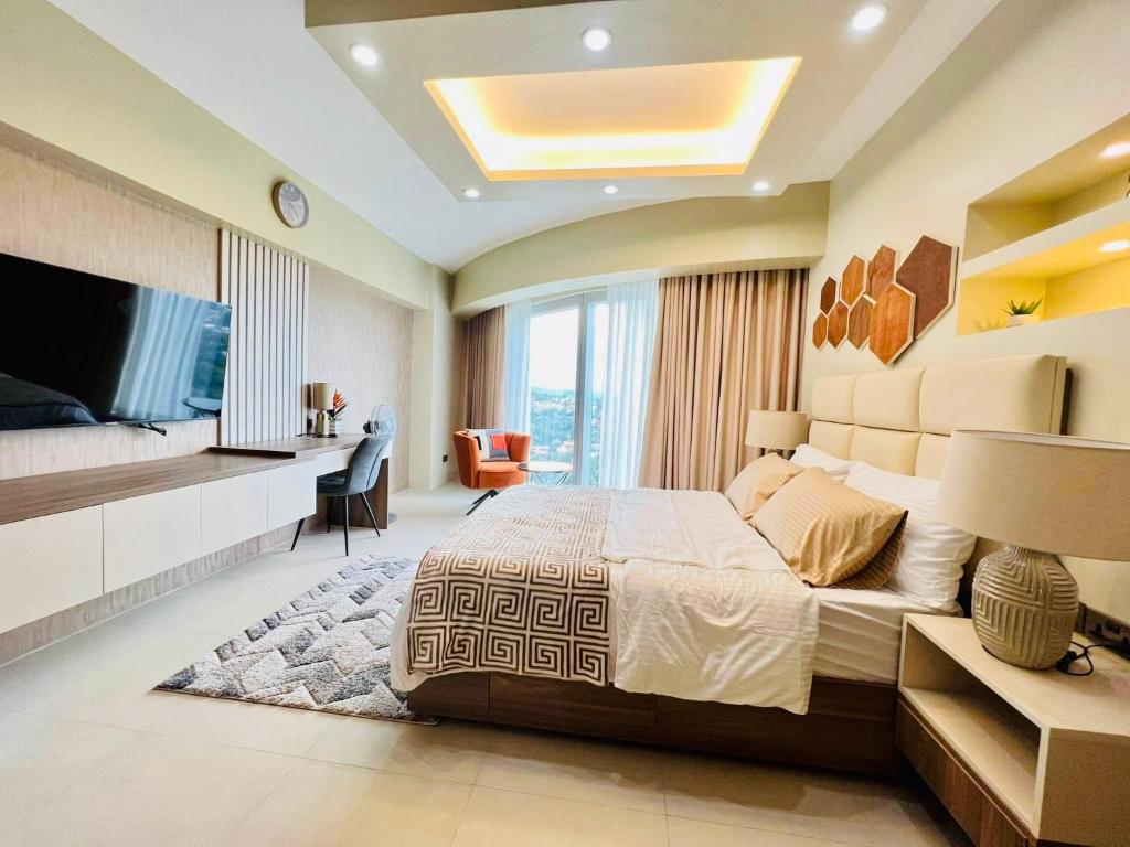 a bedroom with a large bed and a flat screen tv at AEON TOWERS STUDIO SUITE (by:skyspottravelcentra) in Davao City
