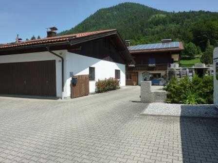 een groot gebouw met een garage en een huis bij Ferienwohnung Del Toso in Schliersee