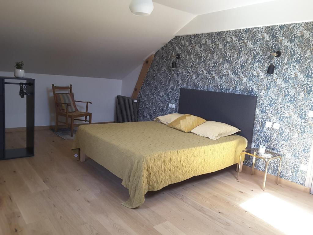 a bedroom with a bed with a blue wall at Le Suc du Pommier in Yssingeaux