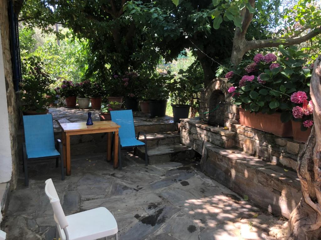 a patio with a table and chairs and flowers at Poraika studios in Raches