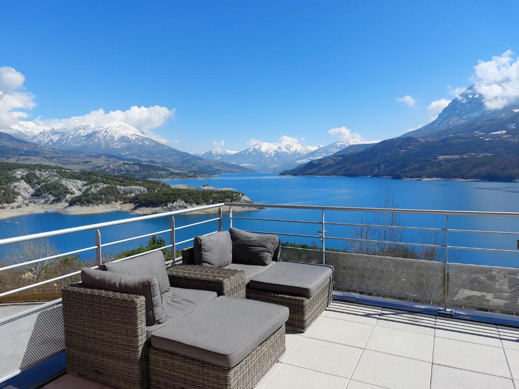 a balcony with a view of a lake and mountains at leparadisachorges in Chorges