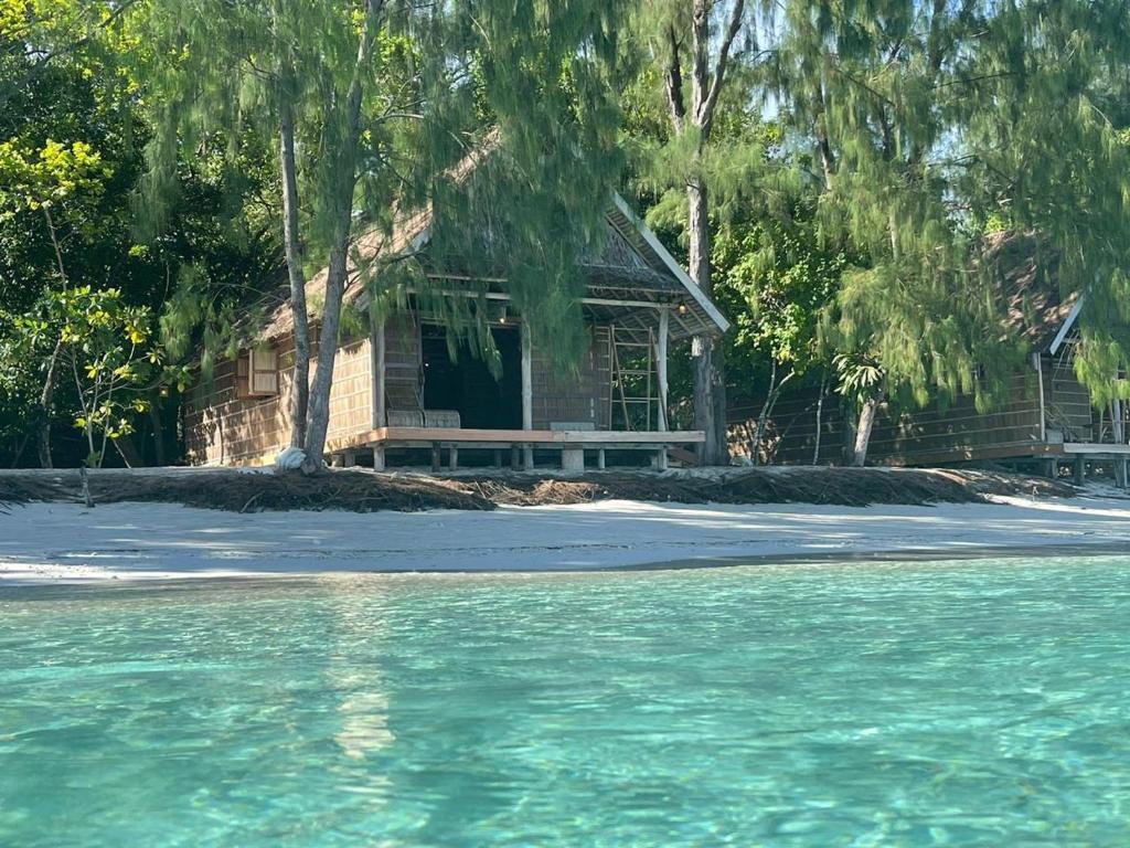 a house sitting on the shore of a beach at Wai Resort - Raja Ampat in Pulau Birie