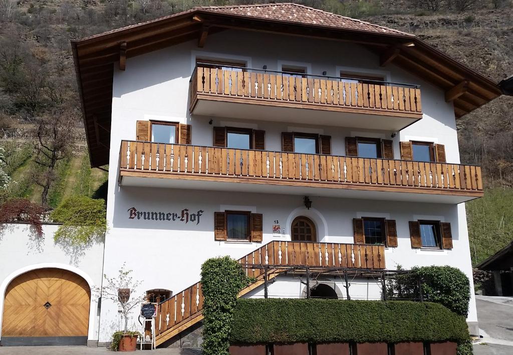 Ferienwohnung Brunnerhof في ناتورنو: منزل به شرفات خشبية على جبل