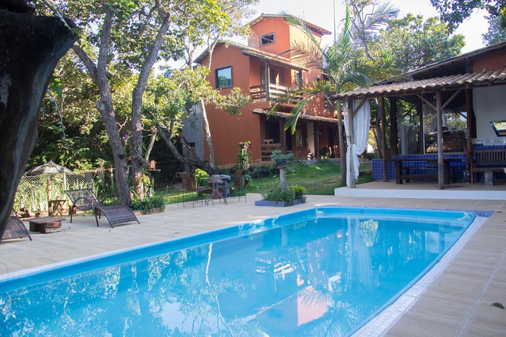 a swimming pool in front of a house at Vila Flores Pousada in Serra do Cipo