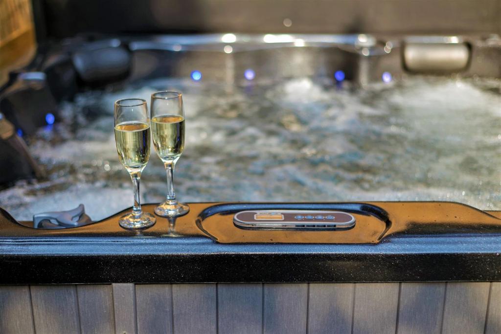 twee glazen champagne op een dienblad in een bad bij Secret Wellness Droombos in Holten