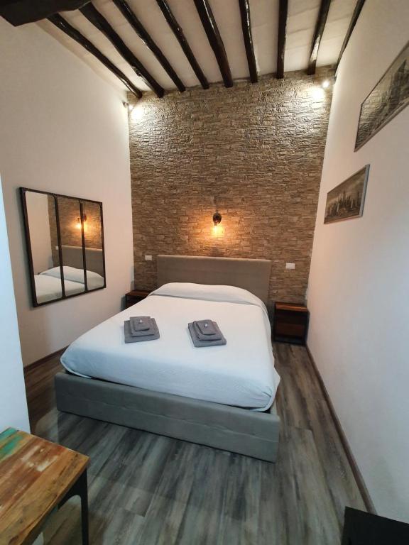 a bed in a room with a brick wall at Residenza la Mandorla in Perugia