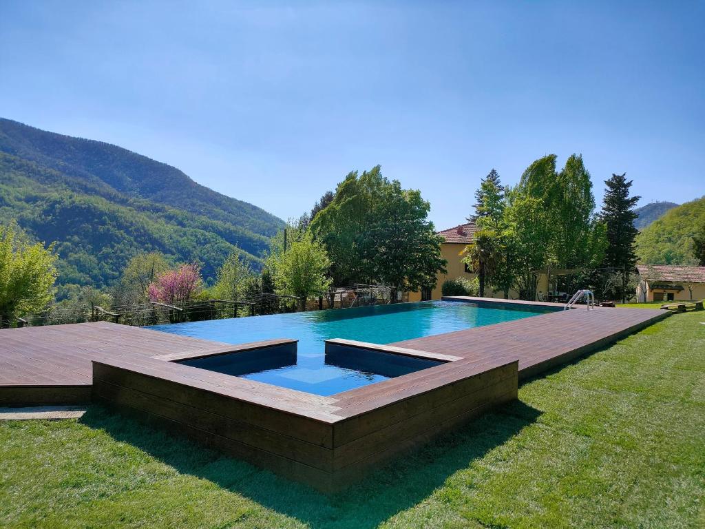 a swimming pool in a yard with a wooden deck at Residenza il palazzo dal 1894 in Pugliano