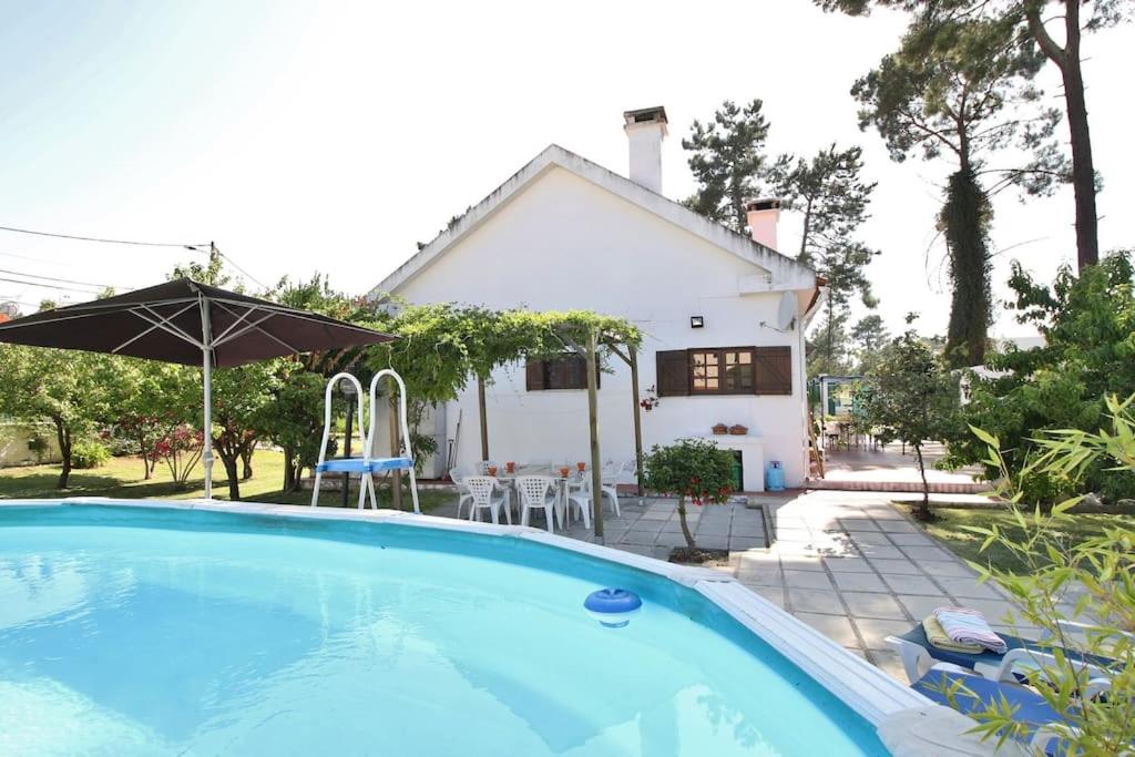an image of a swimming pool in front of a house at Casa;campo-praia-Lisboa (4 quartos) in Corroios
