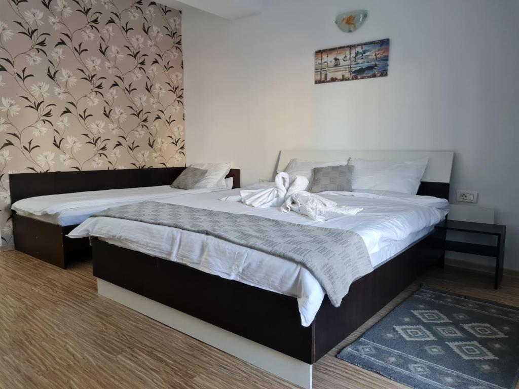 a bedroom with two beds with white sheets at ingrid in Mangalia