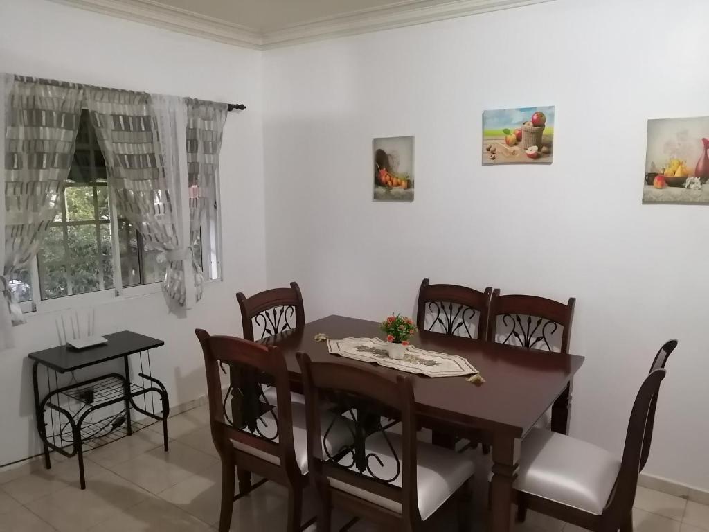 ein Esszimmer mit einem Holztisch und Stühlen in der Unterkunft Appartamento Isabelita los tres ojos Santo Domingo este in Santo Domingo
