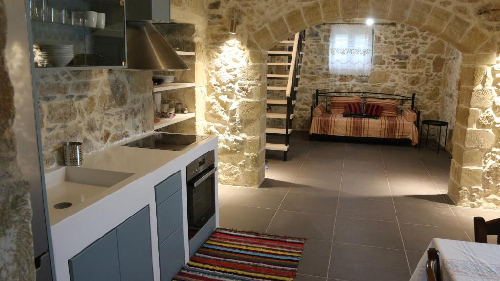 eine Küche mit einem Waschbecken und ein Bett in einem Zimmer in der Unterkunft Mouri Village in Aïkiryiánnis